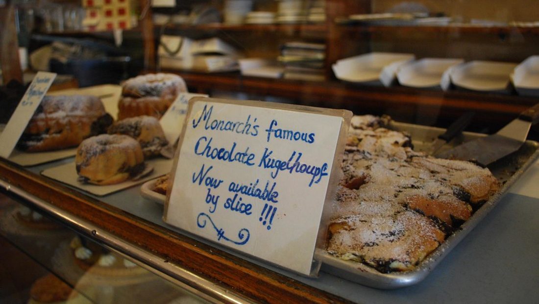 The front counter of my coffee shop and bakery — espresso machine on one side, bread shelves on the other