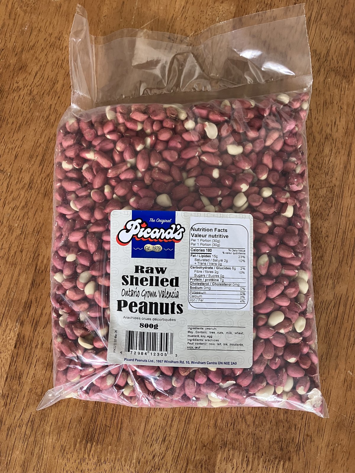 Shelled Valencia peanuts — the bright red skins are the giveaway, and the same characteristic a Chinese bag advertises as 红皮花生