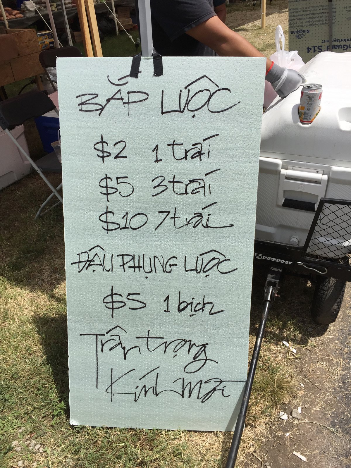 A hand-lettered price board for bắp luộc and đậu phộng luộc — boiled corn and boiled peanuts