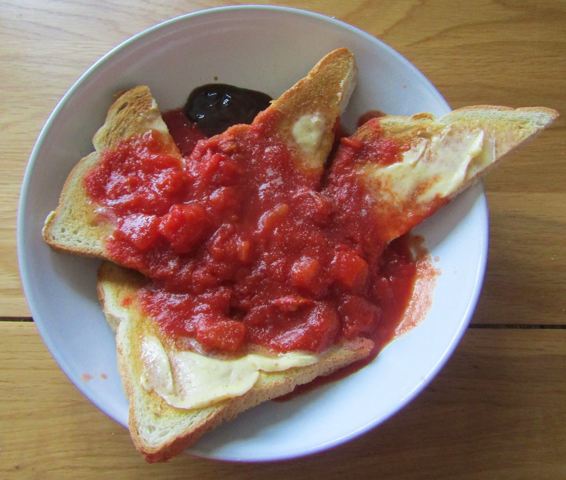 Toast in a bowl with hot canned tomatoes poured over it