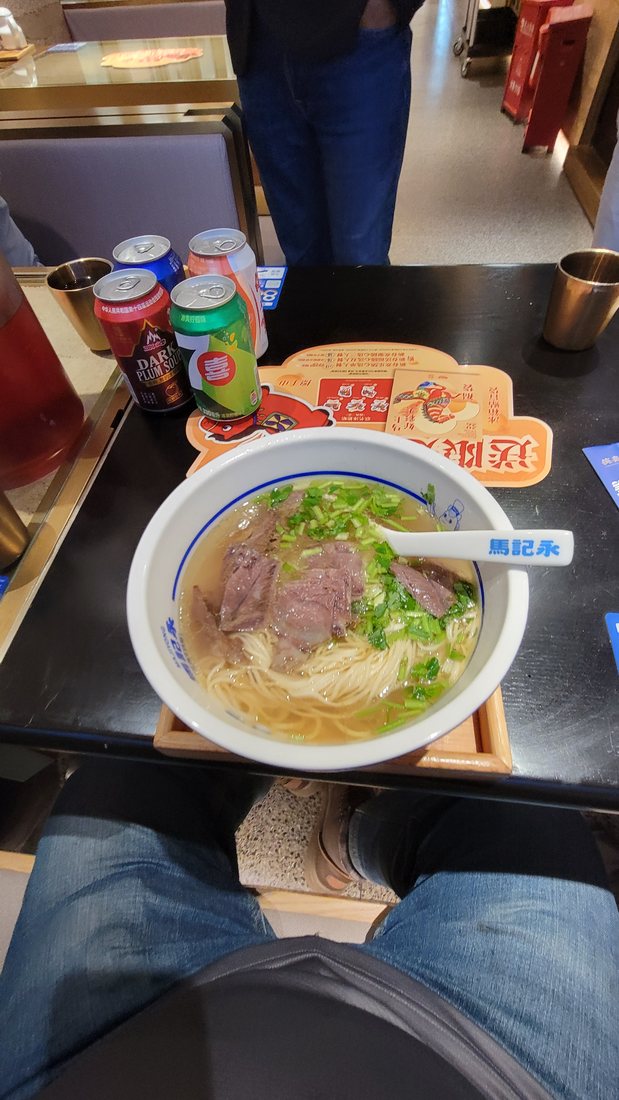 The bowl: clear broth, thin wheat noodles, sliced beef, a heavy lift of green onion