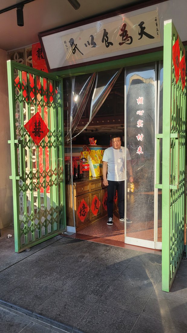 The doorway, with the plaque reading 民以食为天