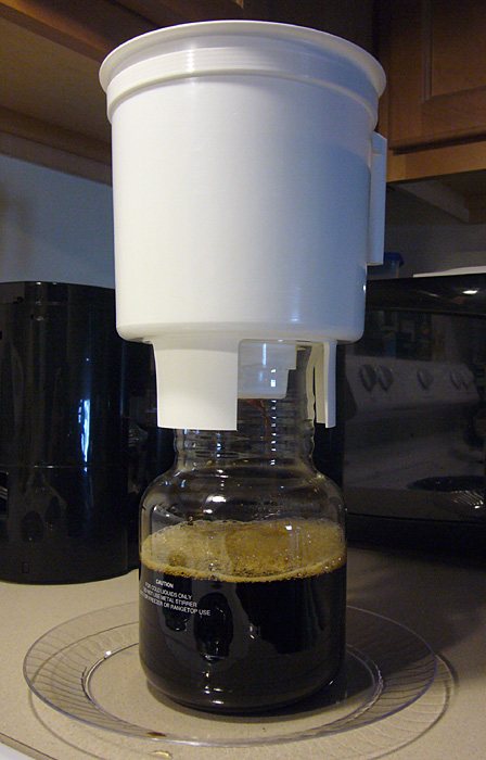 A Toddy-style cold brew system draining into its decanter — a bucket, a filter, and twelve to twenty-four hours of patience. What comes out is concentrate, not coffee