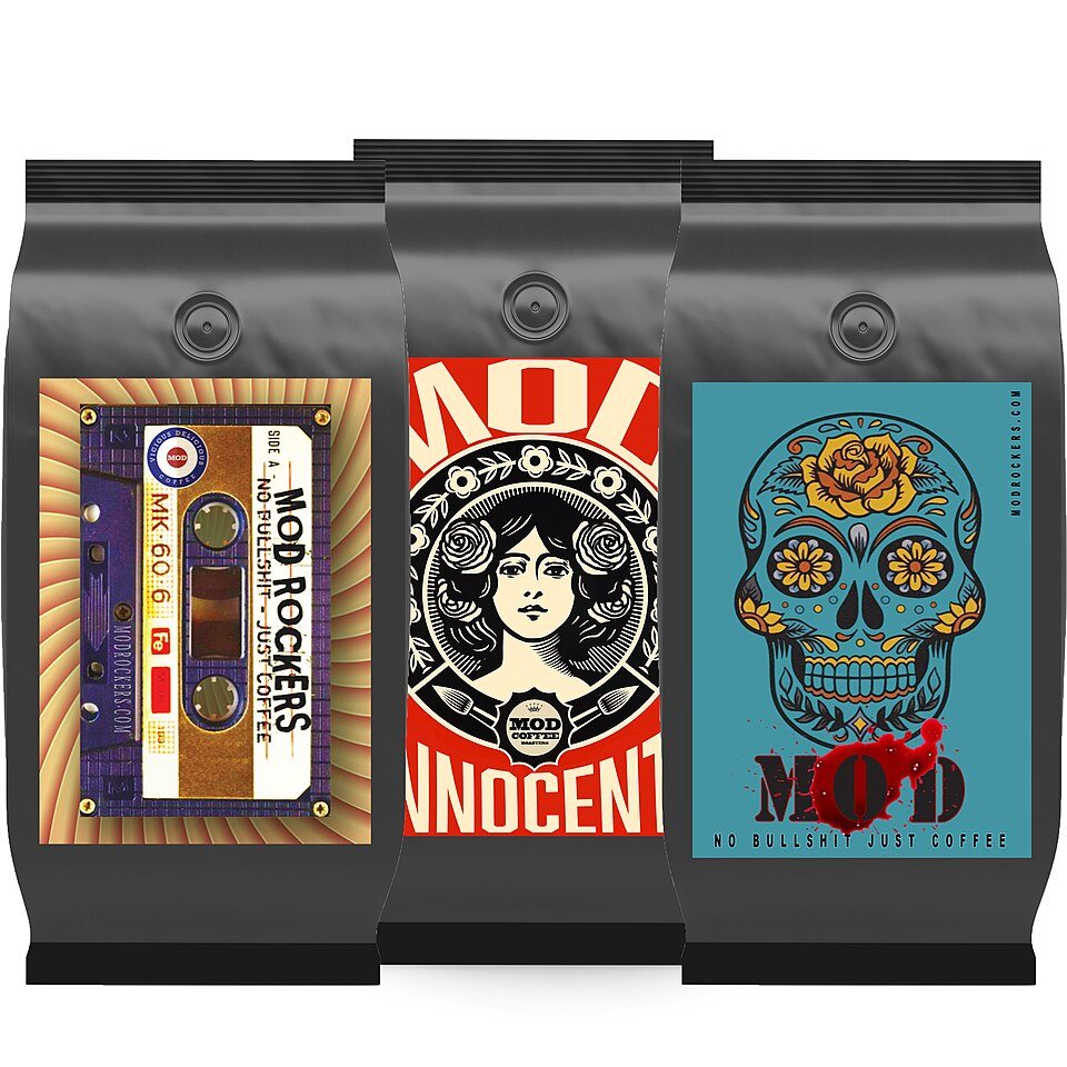Three black coffee bags side by side, each with a large, brightly illustrated label