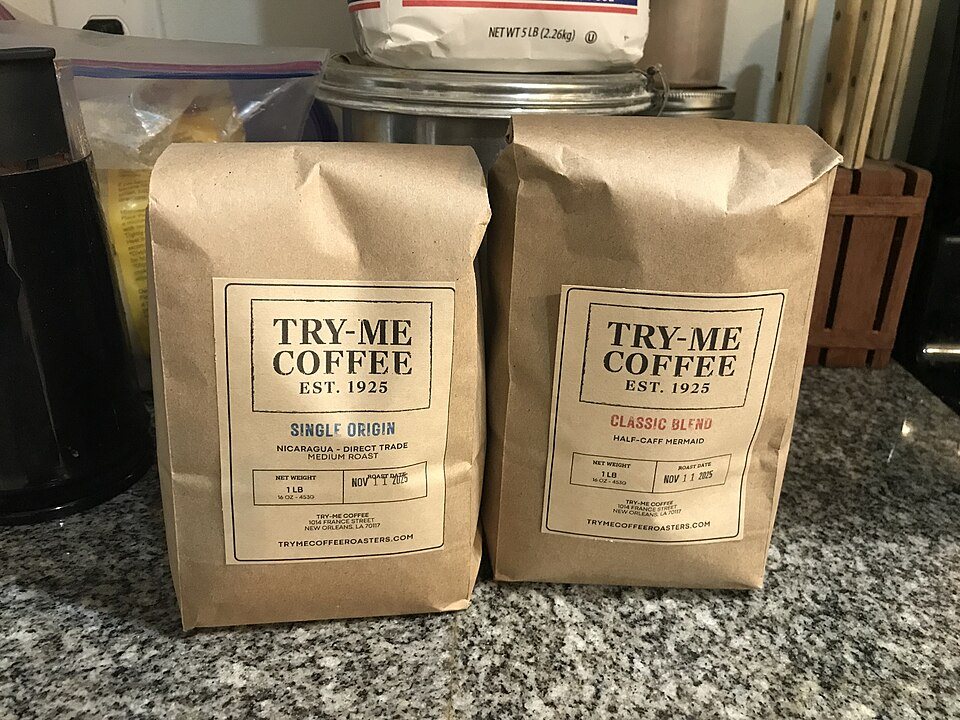 Two kraft paper one-pound coffee bags with printed labels standing on a granite kitchen counter