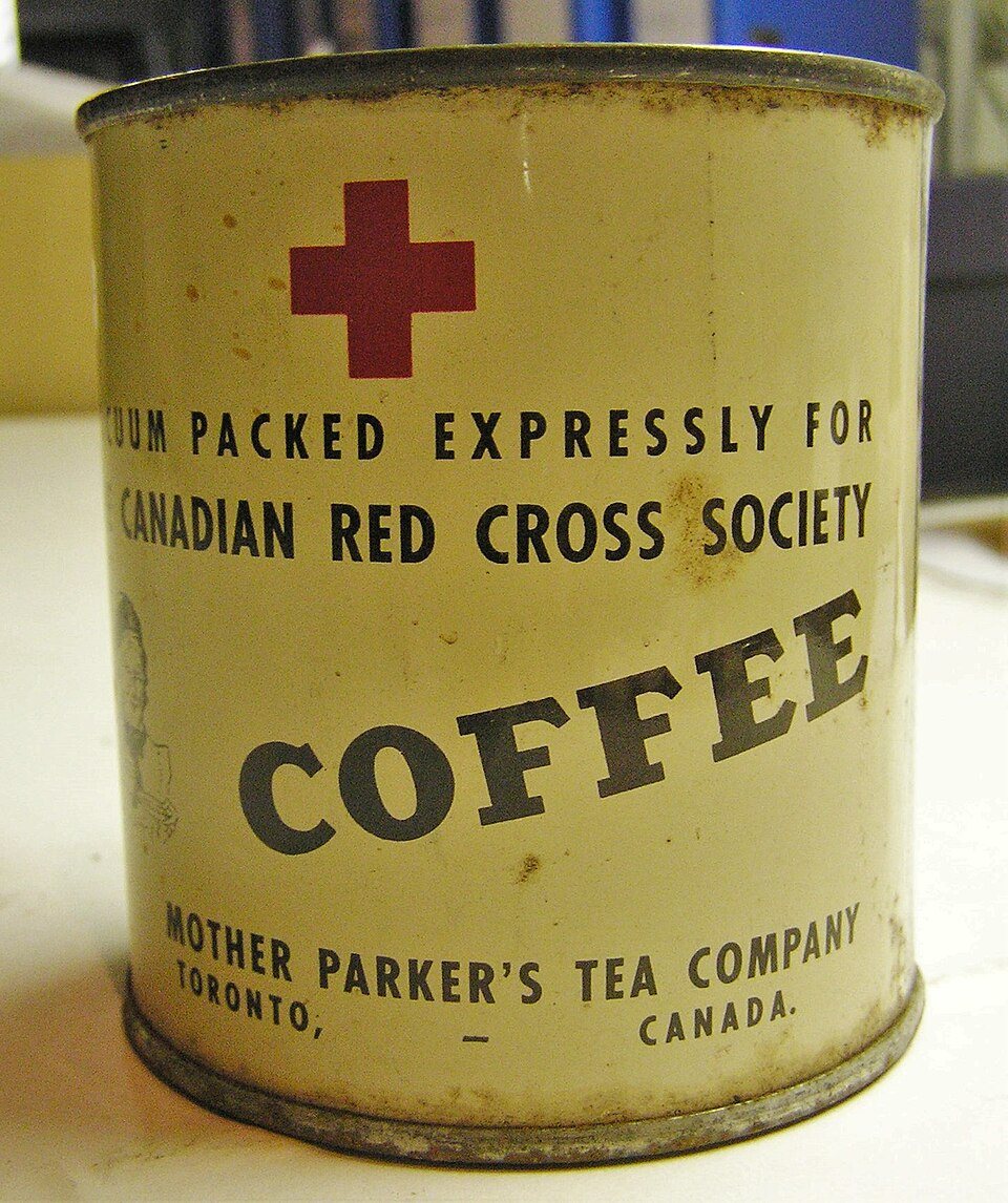 A cylindrical tin can with a yellow label and a red cross reading vacuum packed expressly for Canadian Red Cross Society, coffee, Mother Parker's Tea Company, Toronto