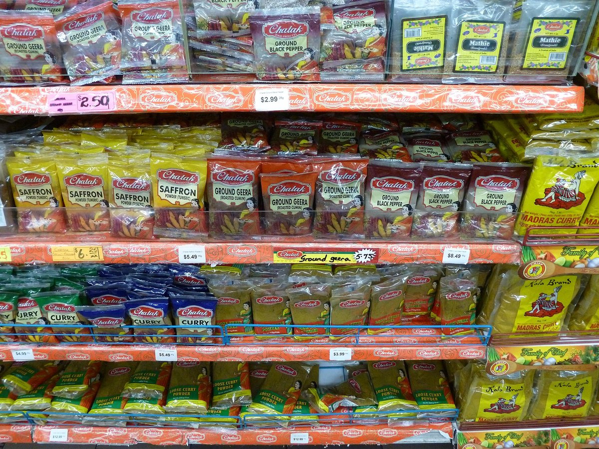 A supermarket spice aisle in Trinidad and Tobago — curry powder as an everyday local staple, not an import