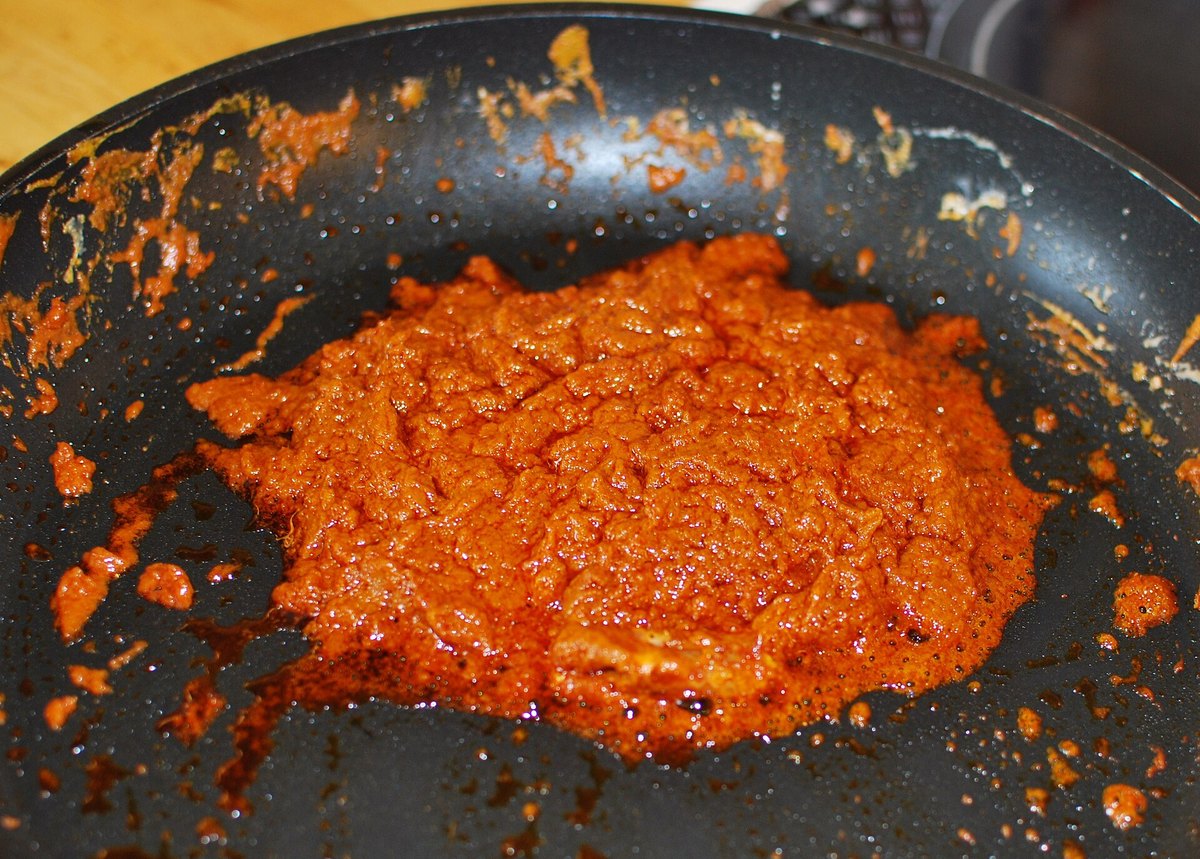 Coconut cream separating in the pan, with clear coconut oil pooling at the edges — the point at which the paste goes in