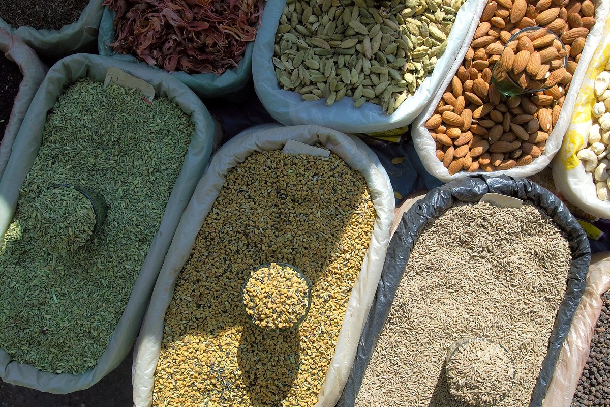 A market spice display — dozens of separate seeds, powders and pods in open bowls. There is no single thing here called curry