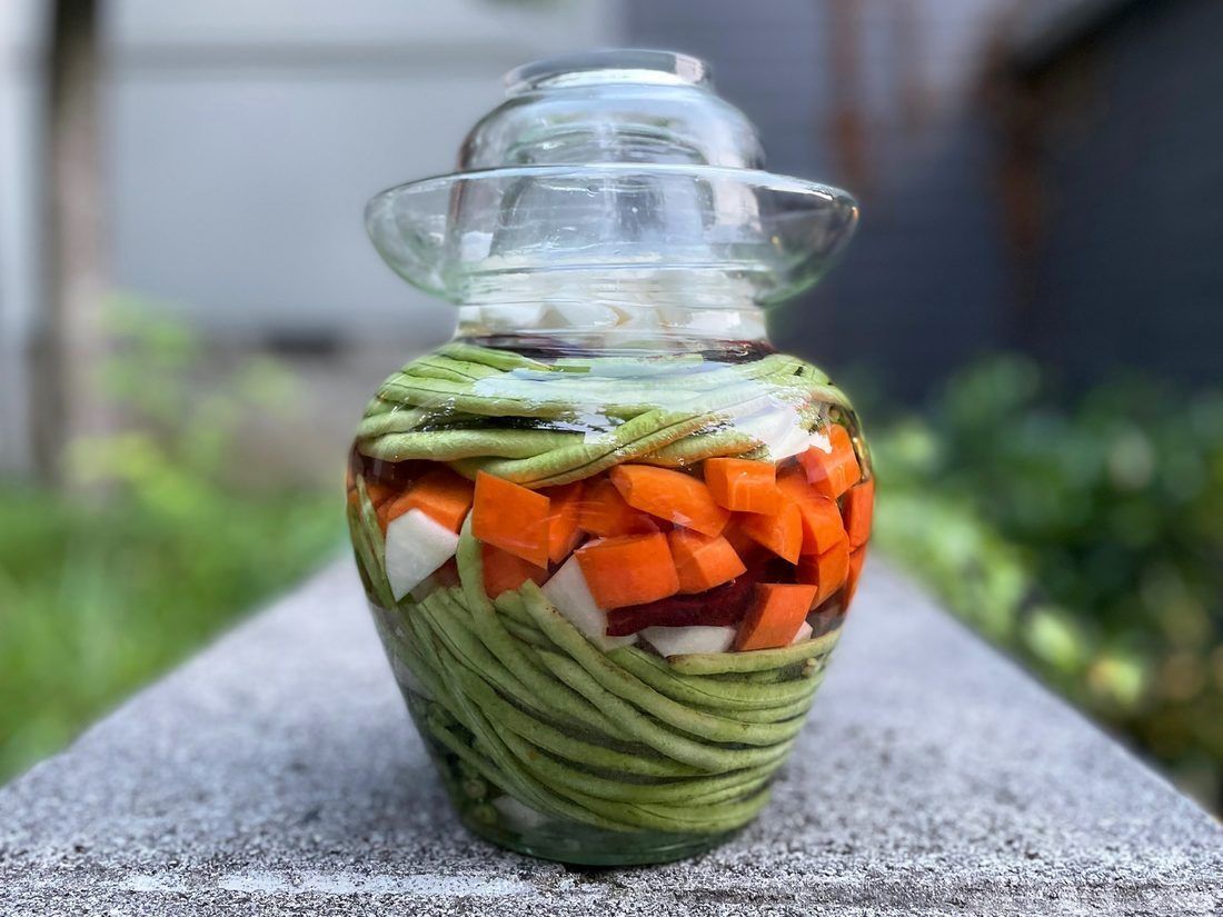 A Sichuan pickle jar. The rim is a water channel and the inverted lid sits in it — the same one-way seal as a German Gärtopf, arrived at separately