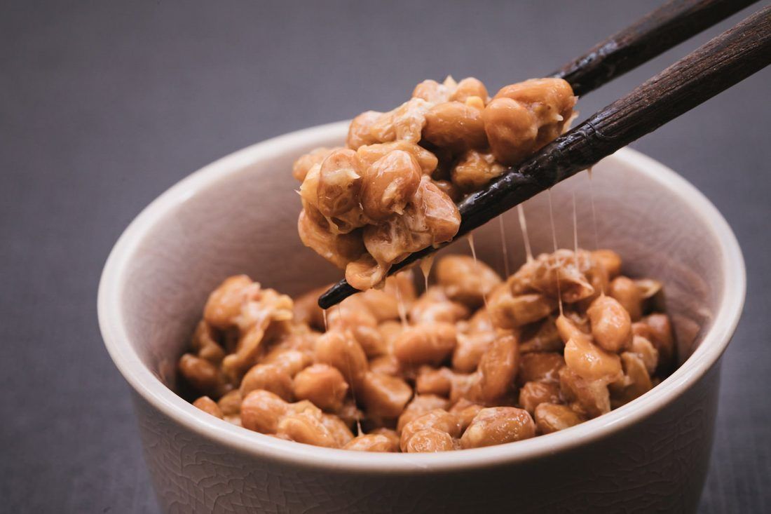 Natto lifted with chopsticks, pulling the strings it is famous for