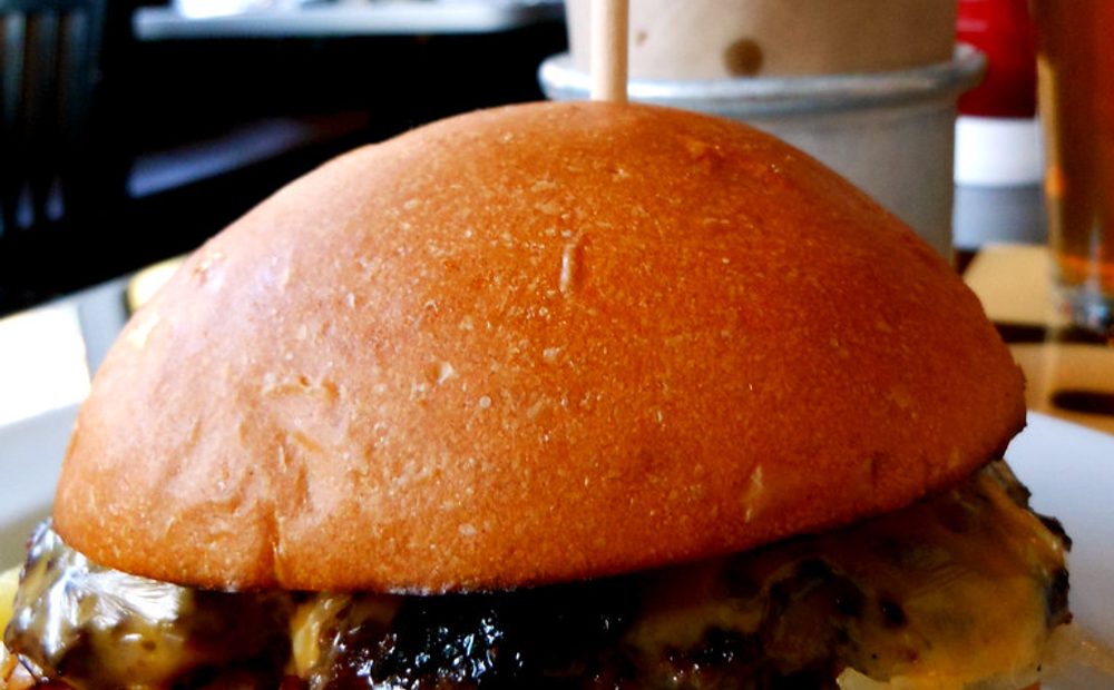Smash burgers developing crust on the flat-top (placeholder for my service)