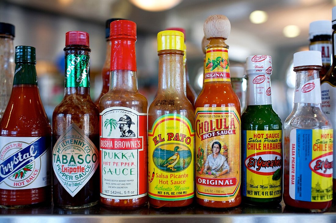 A row of American and Mexican hot-sauce bottles including Crystal, Tabasco, Cholula and El Pato