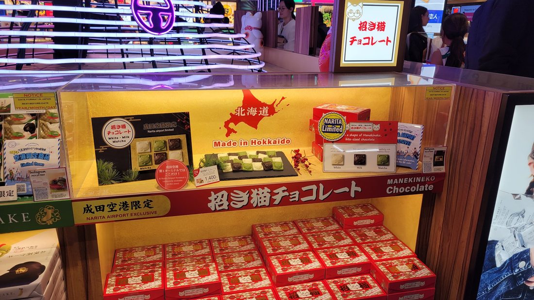The Narita-exclusive maneki-neko chocolate — 招き猫チョコレート, in the red boxes