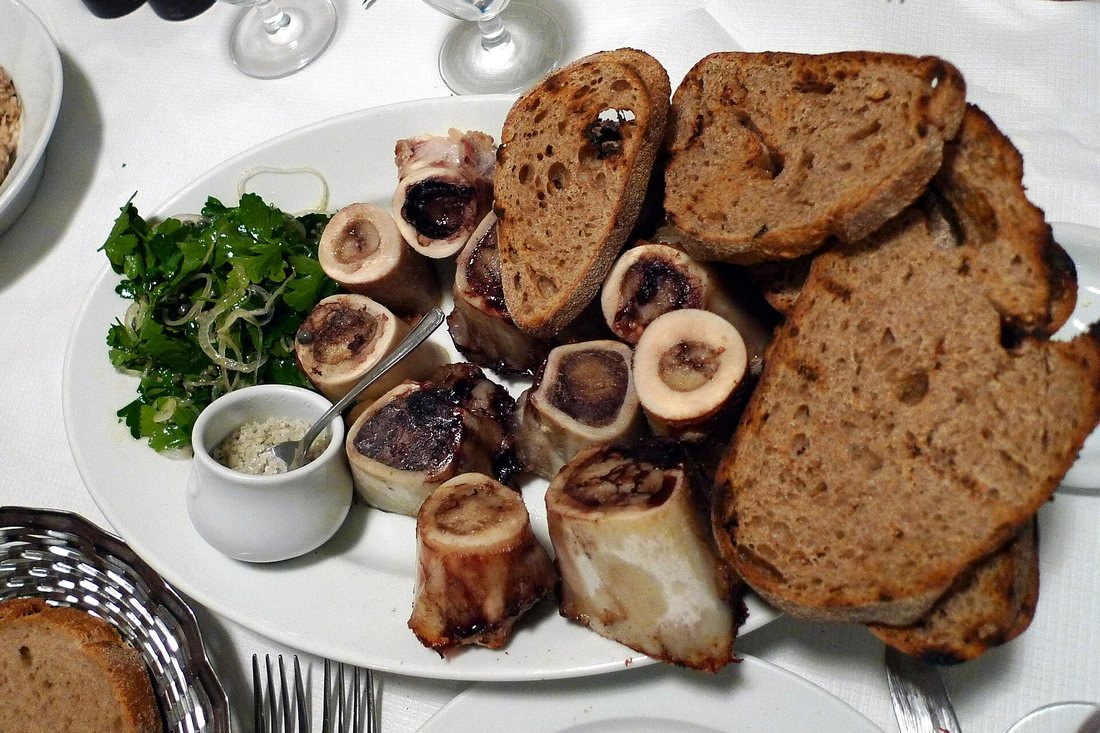 A platter of cut roast marrow bones with sourdough toast, parsley salad and salt at St John in London