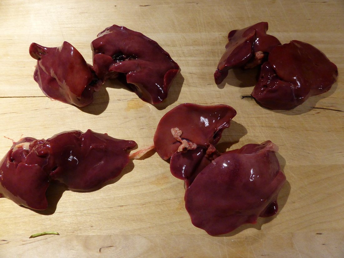 Raw chicken livers on a wooden cutting board