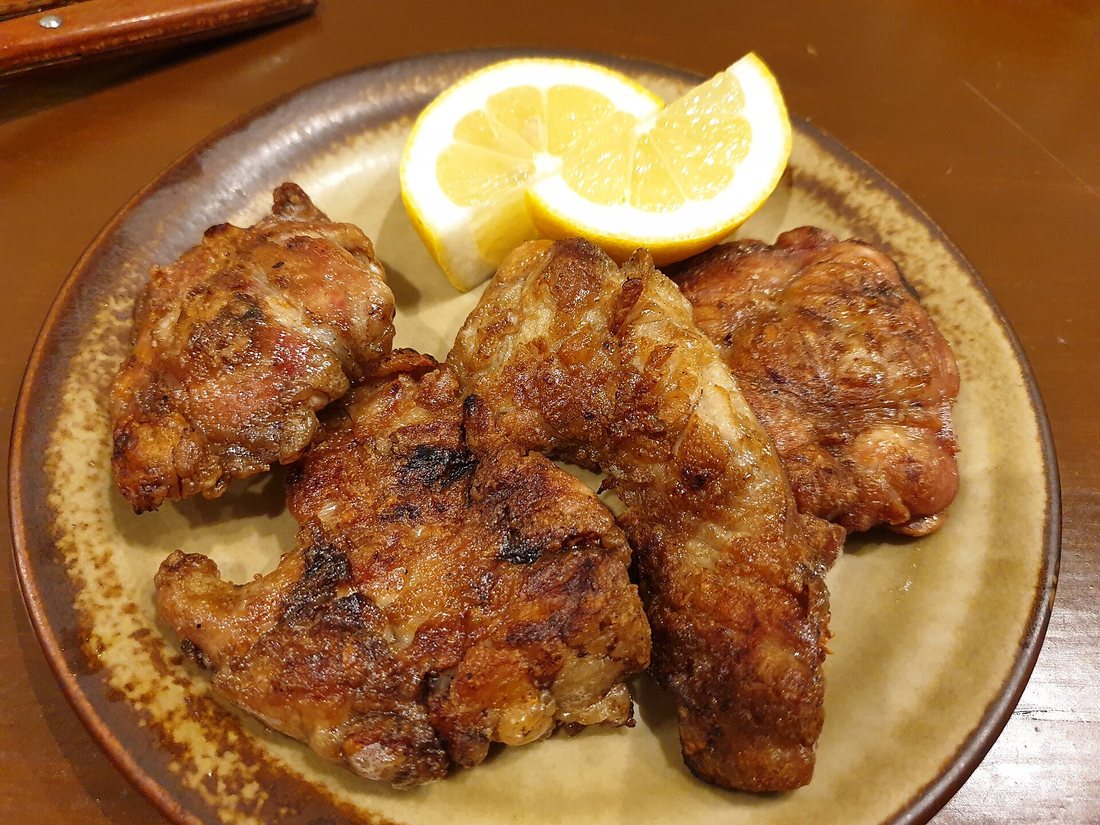 Grilled sweetbreads (mollejas) with lemon wedges on a plate