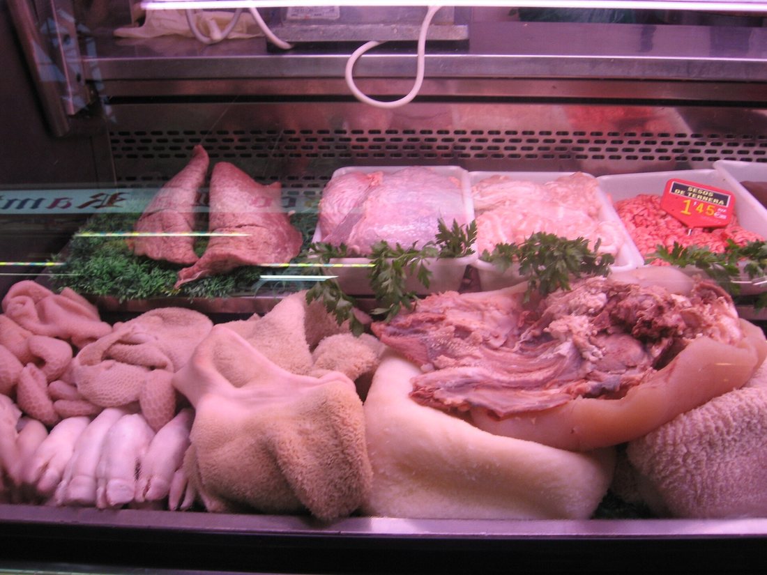 An offal counter at La Boqueria market in Barcelona, with tripe, lamb's feet, lungs and hearts under pink display lights