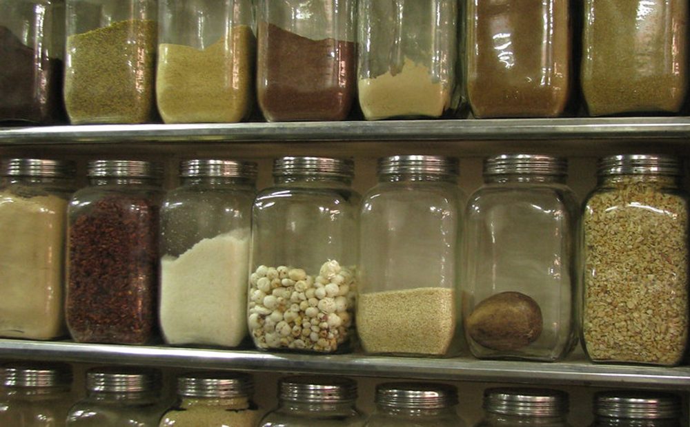 Jeff's own vinegar-pickle shelf — a row of his jarred dills, red onions, and giardiniera against the light (placeholder)