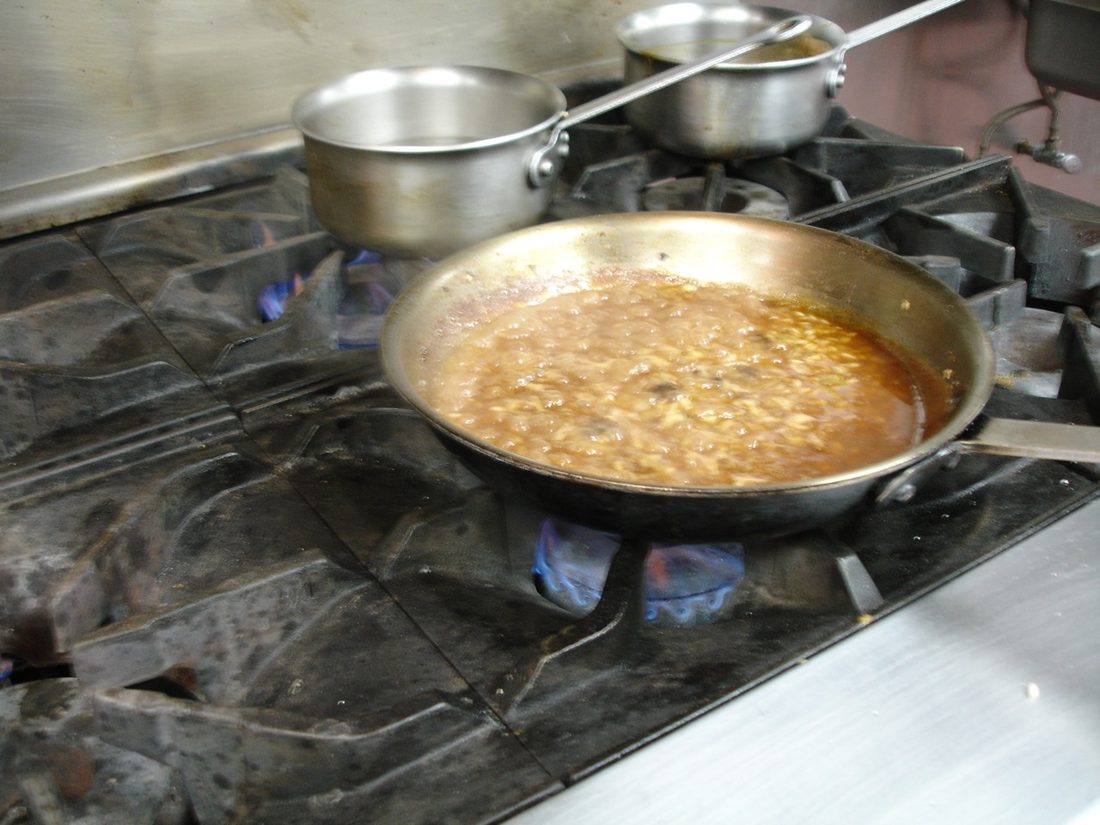 Creamy risotto being stirred in a pan, the grains loose in a glossy starch-thickened sauce