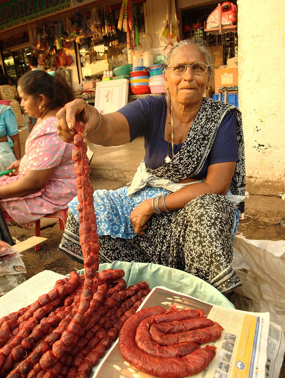 Goan chouriço sold in strings at market — vinegar-and-chile cured pork, Portugal's fingerprint on Catholic Goa.