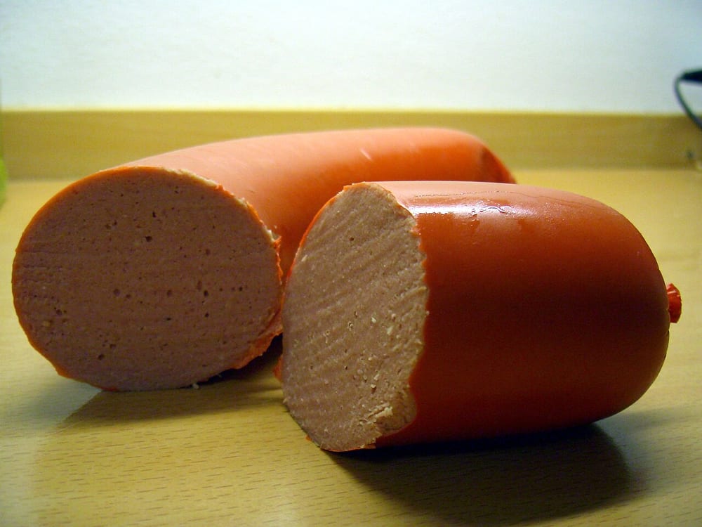 A thick falukorv loaf, the cut end showing its mild, pale-pink interior