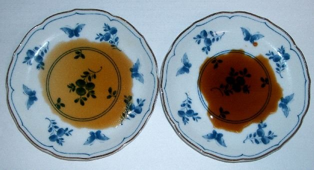 Two small blue-and-white plates side by side, one holding pale amber usukuchi, the other dark red-brown koikuchi
