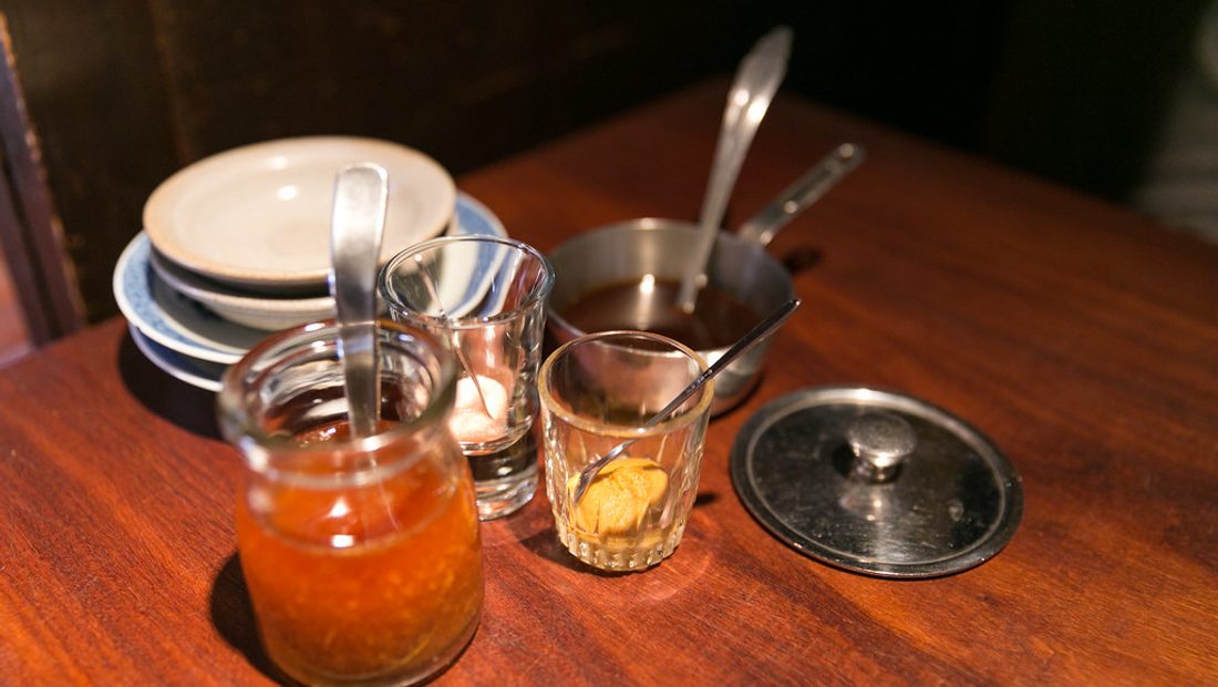 A tabletop spread of Worcestershire's global cousins — Japanese tonkatsu sauce, Salvadoran salsa inglesa, and a classic Lea and Perrins bottle